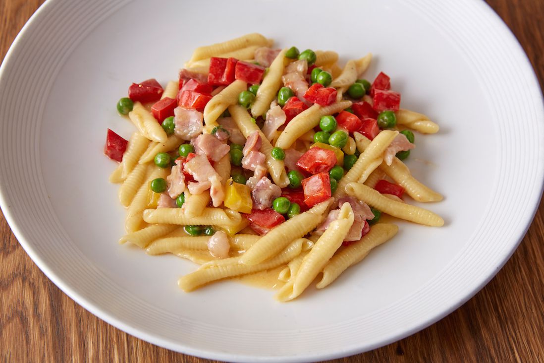 Garganelli with red and yellow peppers sautéed with pancetta and green peas<br>